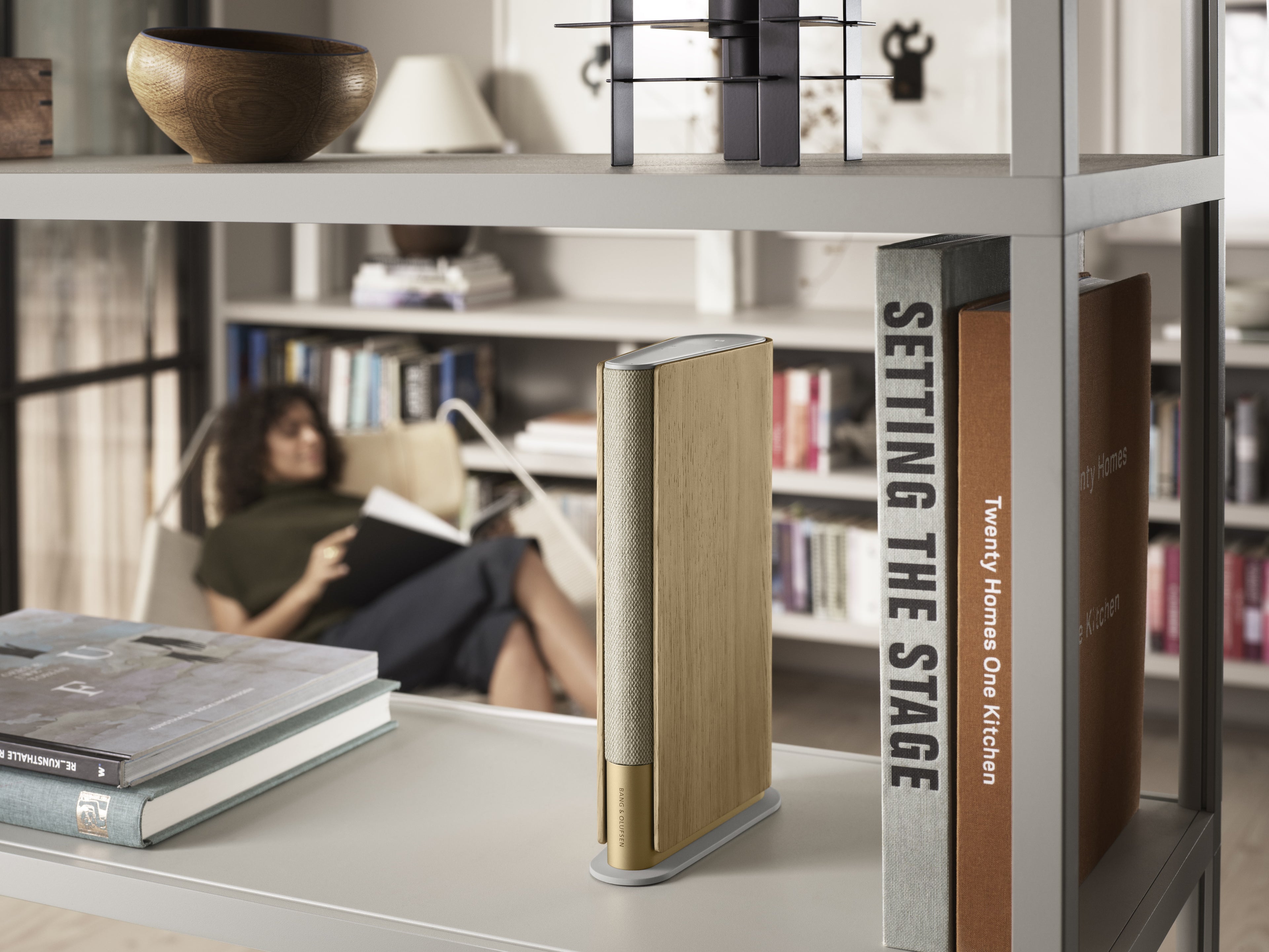 BeoSound Emerge in Gold Tone in einem Bücherregal