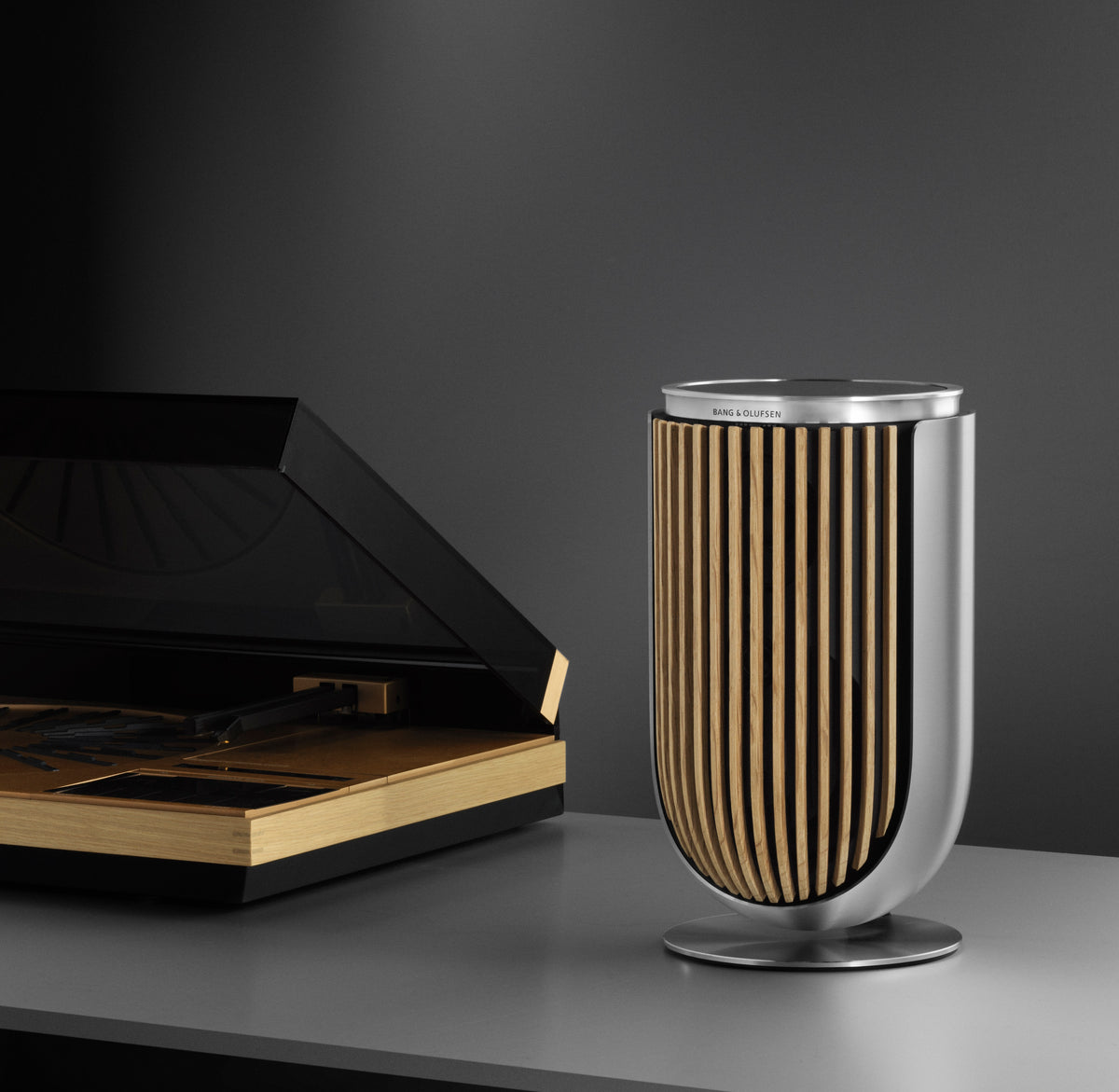 BeoLab 8 in silber mit Cover aus Eichenholz neben einem BeoGram