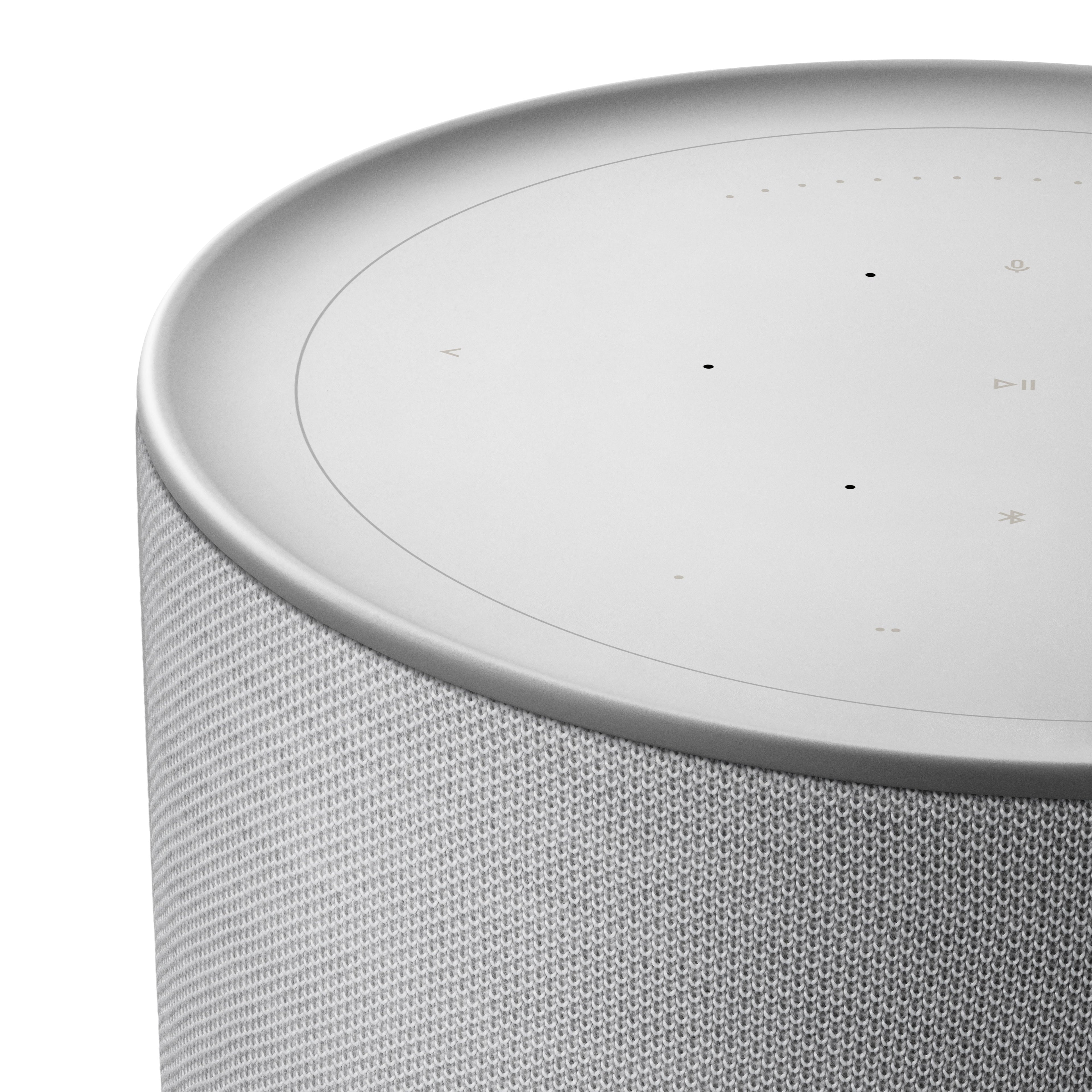 Nahaufnahme der interaktiven Oberseite der Beosound Balance. Die Touch-Oberfläche aus Glas zeigt die beleuchteten Bedienelemente für Wiedergabe, Bluetooth und Favoriten sowie den kreisförmigen Lautstärkeregler.