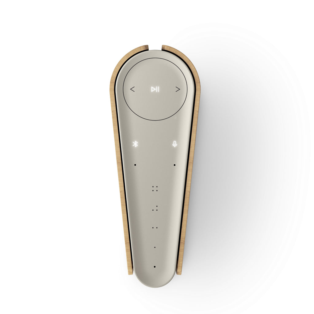 Top-down Ansicht des Beosound Emerge; verdeutlicht die keilförmige 'Buchrücken'-Form und das minimalistische Bedienfeld mit Mikrofon- und Bluetooth-Indikatoren.