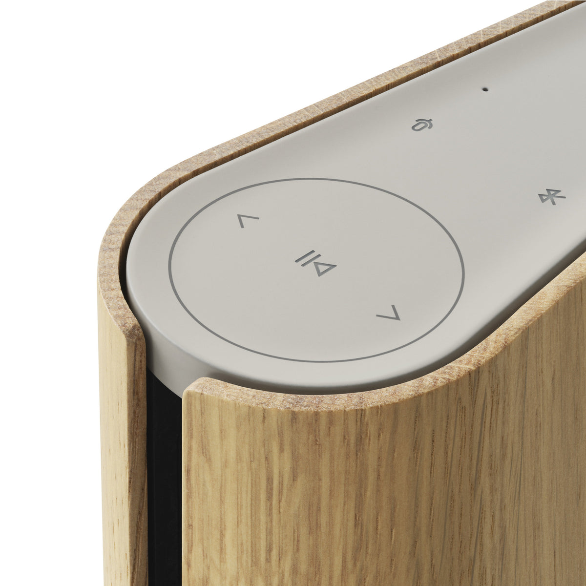Nahaufnahme der intuitiven Touch-Bedienelemente auf der Oberseite des Beosound Emerge (Gold Tone). Symbole für Play/Pause, Lautstärke und Bluetooth sind dezent in die sandfarbene Oberfläche integriert.