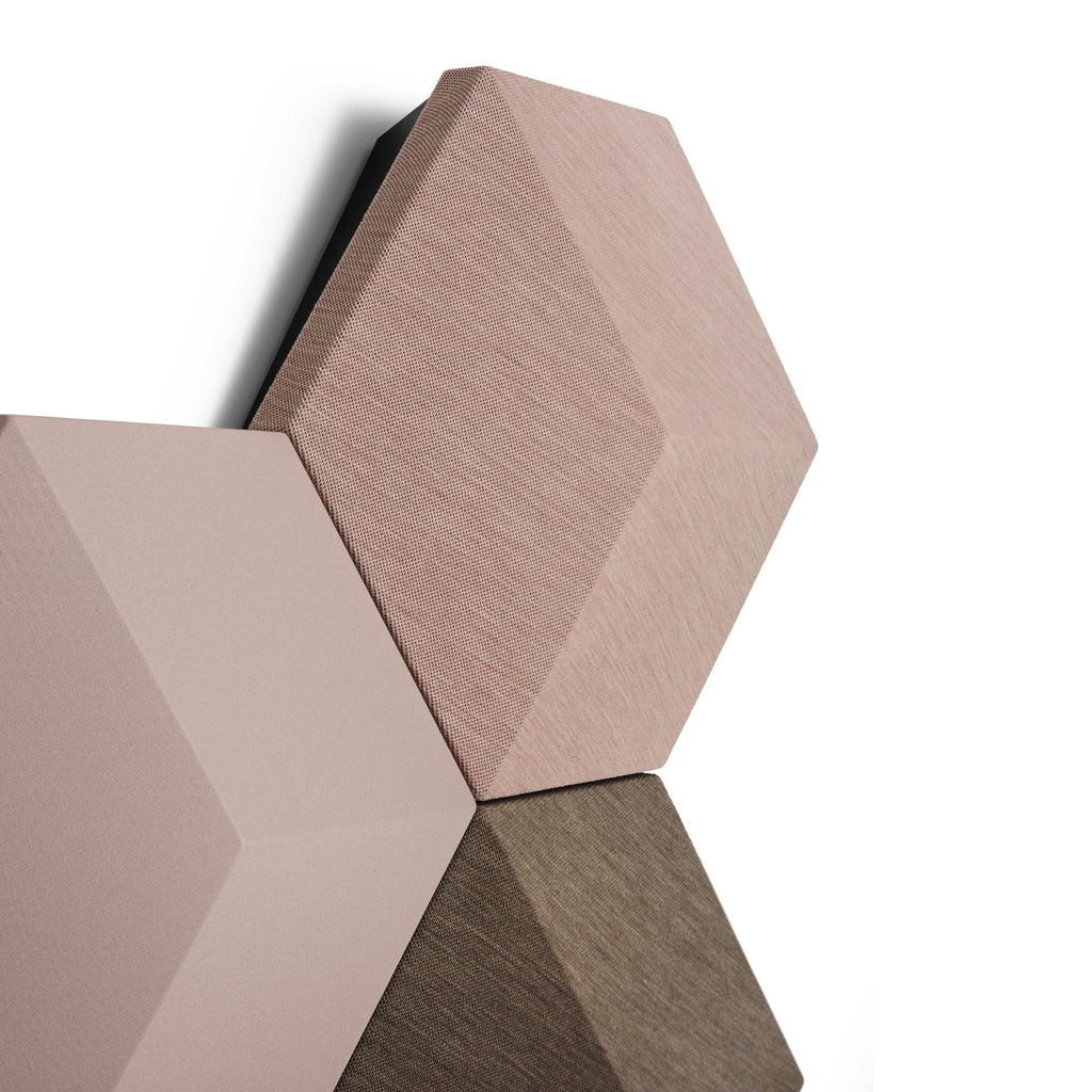 Detailaufnahme des modularen Bang & Olufsen Beosound Shape Lautsprechersystems. Zu sehen sind drei hexagonale Wandpaneele mit hochwertigen Kvadrat-Textilbezügen in aufeinander abgestimmten Erd- und Rosétönen vor weißem Hintergrund.